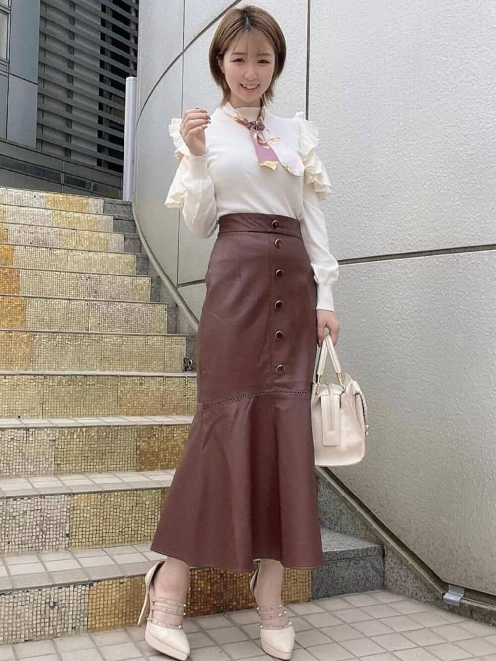 ホワイト系のハンドバッグ、ベージュ系のパンプス、ホワイト系のニット/セーターを着用したレディースの秋コーディネートの1枚目の写真