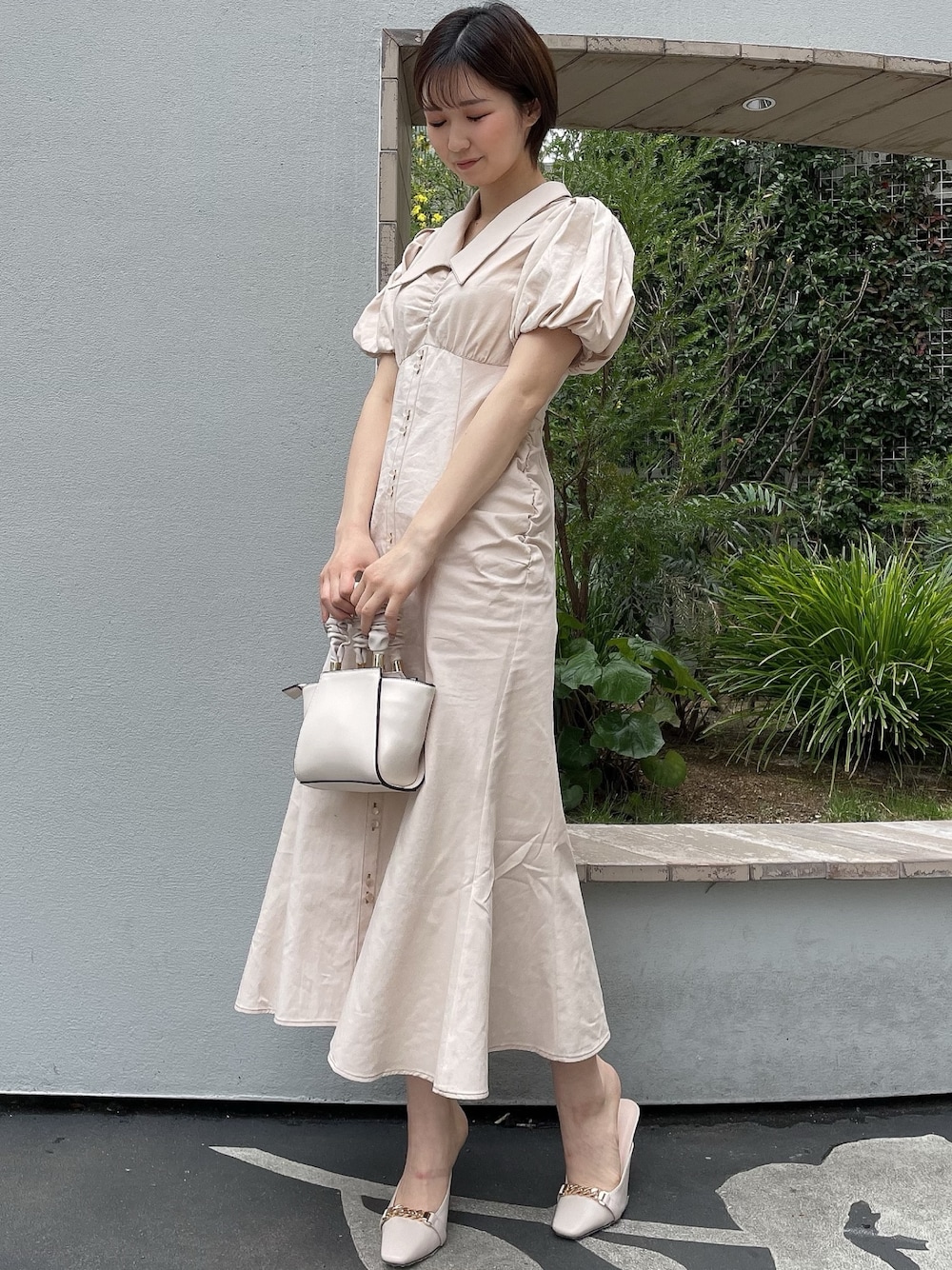 ホワイト系のワンピース、ホワイト系のハンドバッグ、ホワイト系のサンダルを着用したレディースの春コーディネートの1枚目の写真