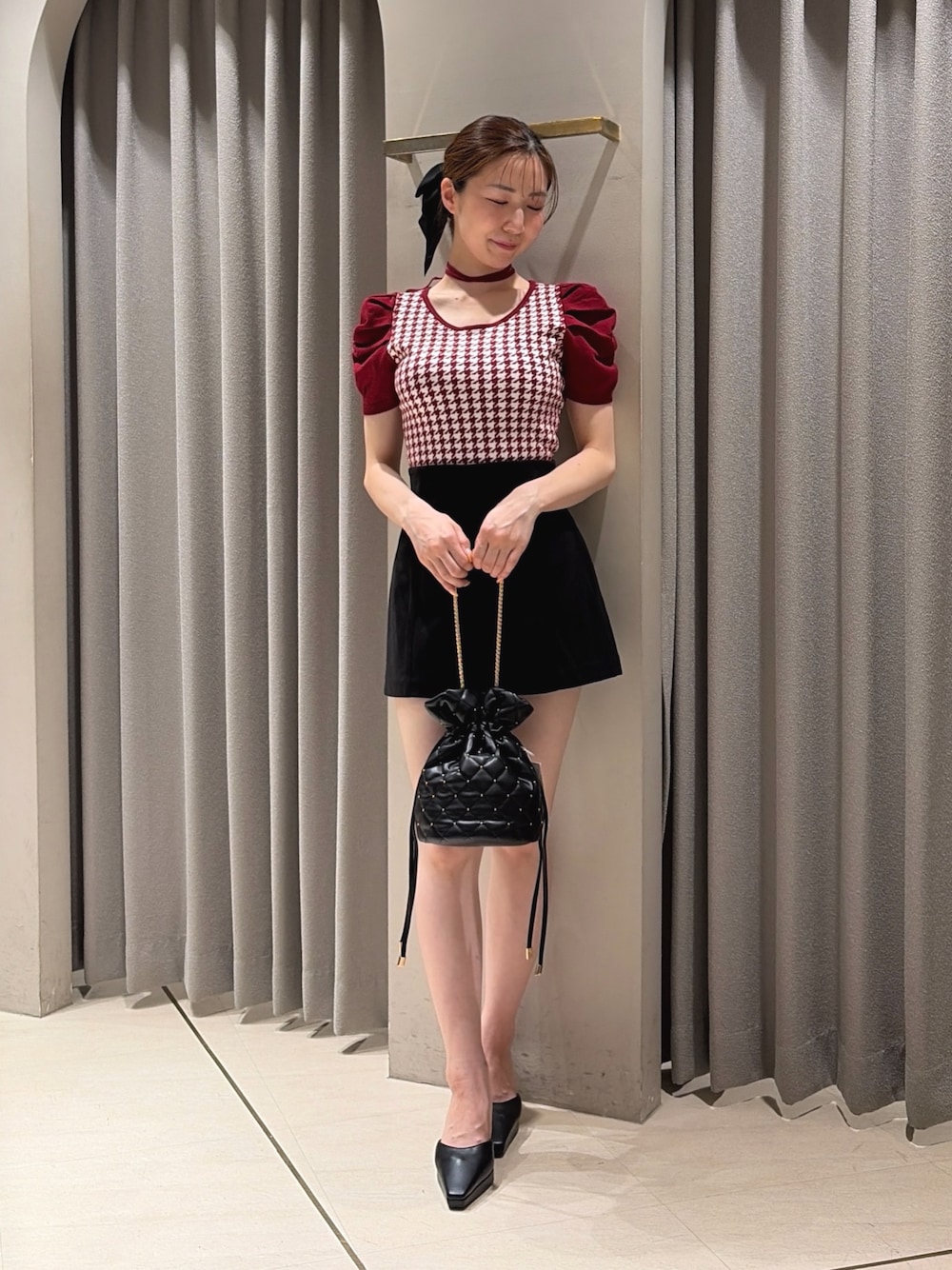 レッド系のニット/セーター、ブラック系のその他パンツ、ブラック系のハンドバッグを着用したレディースの夏コーディネートの1枚目の写真