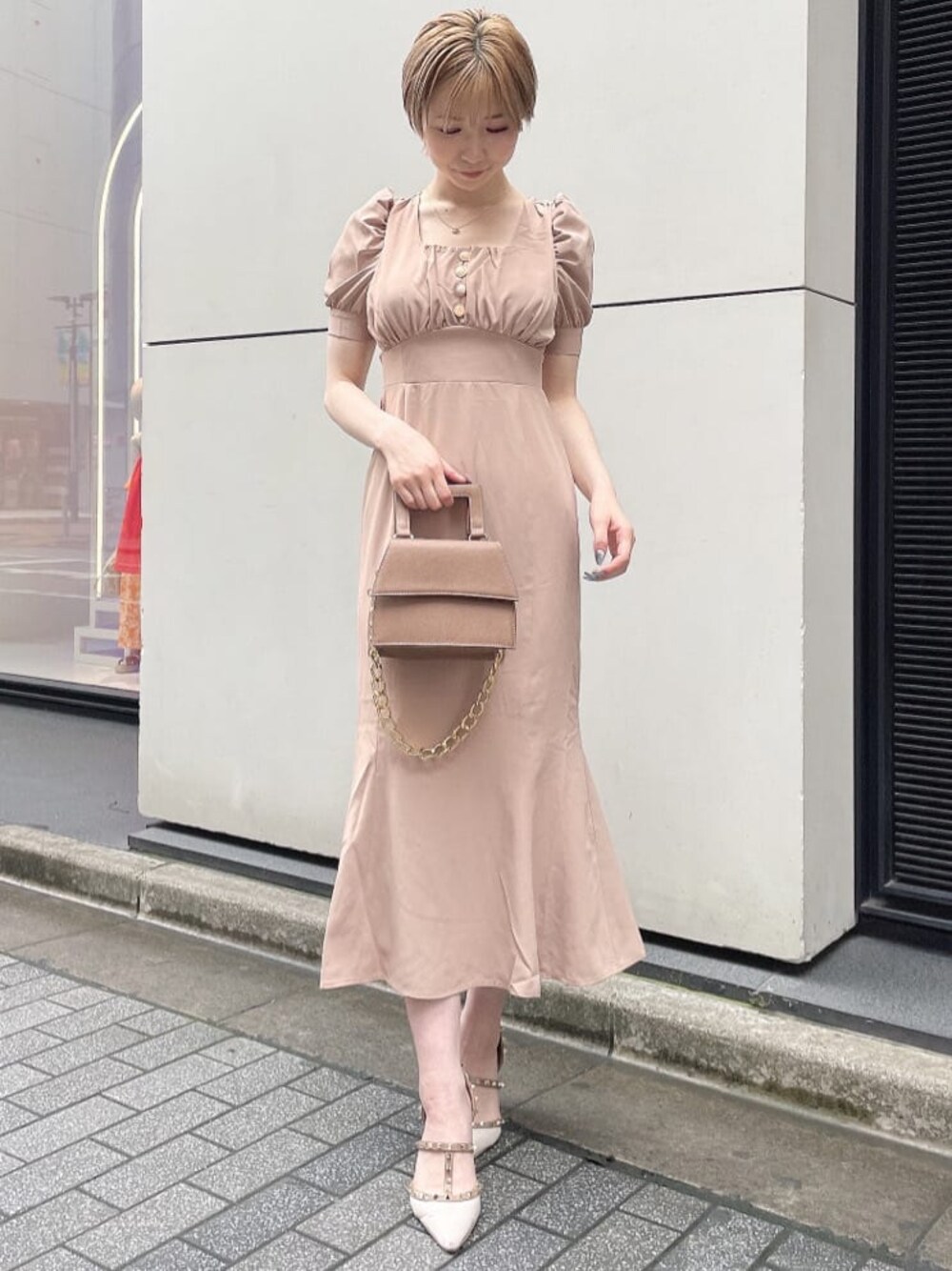 ホワイト系のパンプス、ブラウン系のショルダーバッグ、ピンク系のワンピースを着用したレディースの夏コーディネートの1枚目の写真