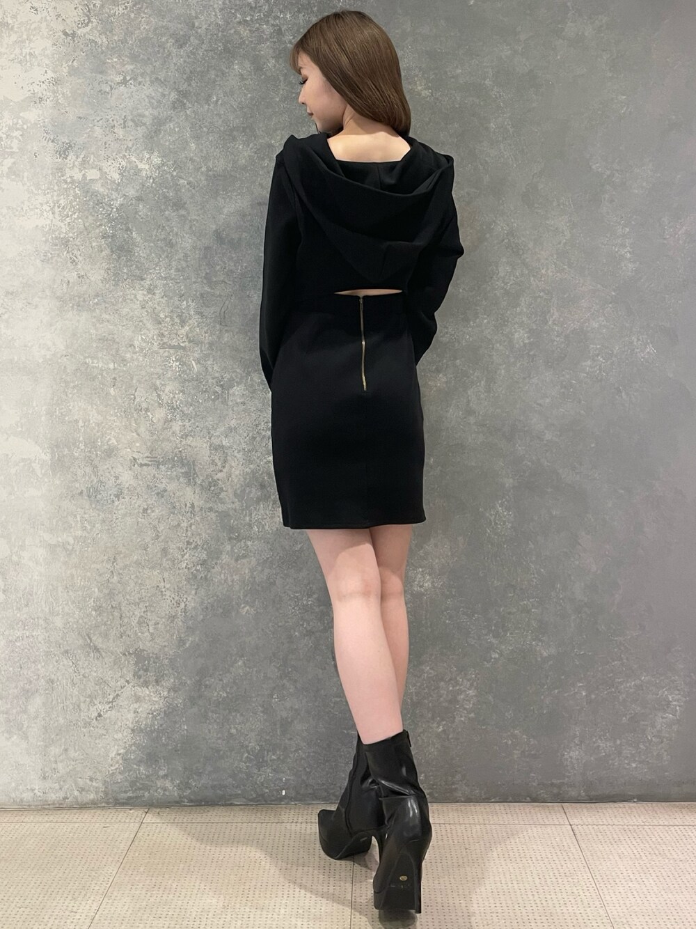 ブラック系のワンピース、ブラック系のブーツを着用したレディースの秋コーディネートの1枚目の写真