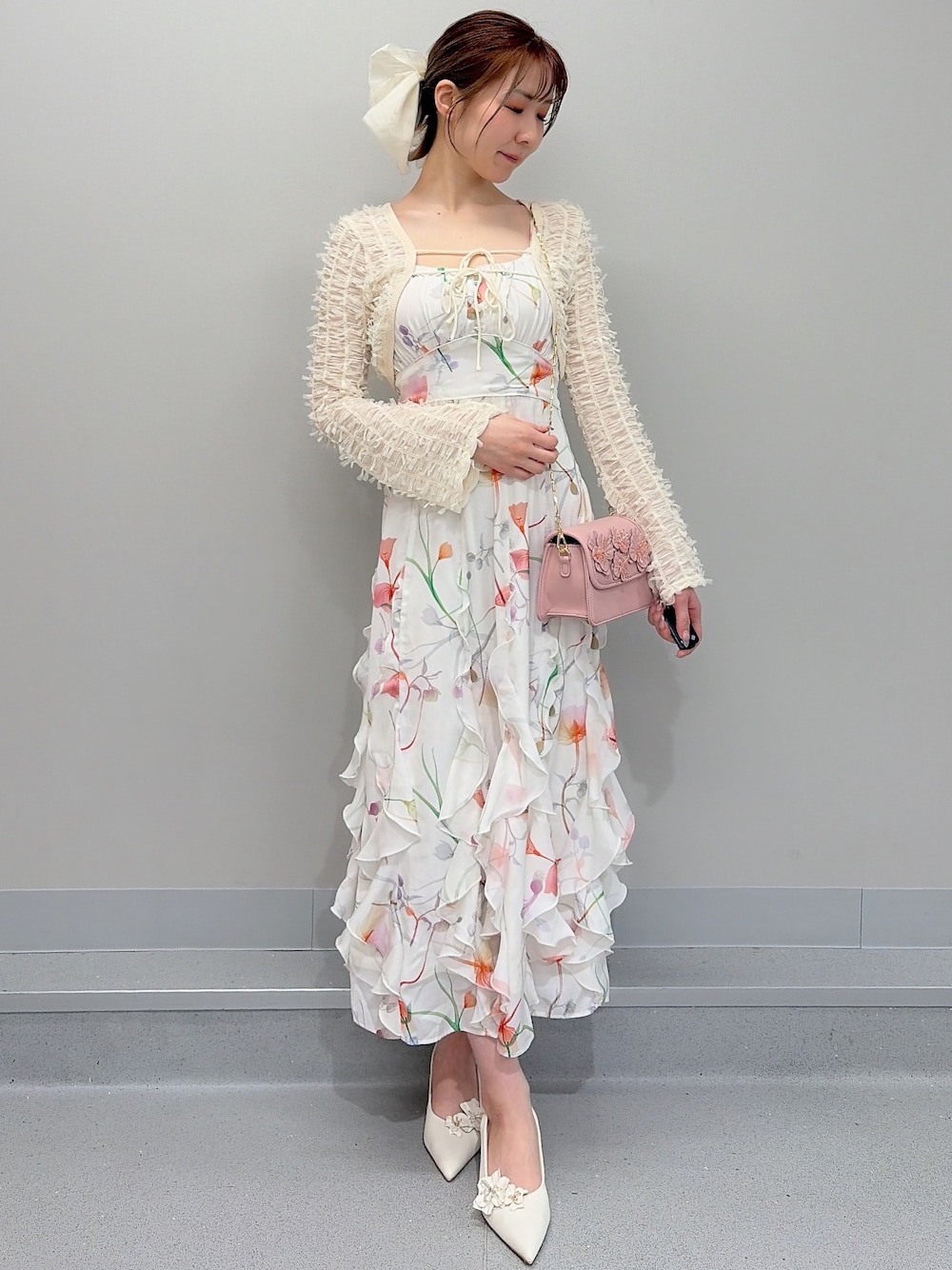 ホワイト系のワンピース、ピンク系のショルダーバッグ、ホワイト系のパンプスを着用したレディースの冬コーディネートの1枚目の写真