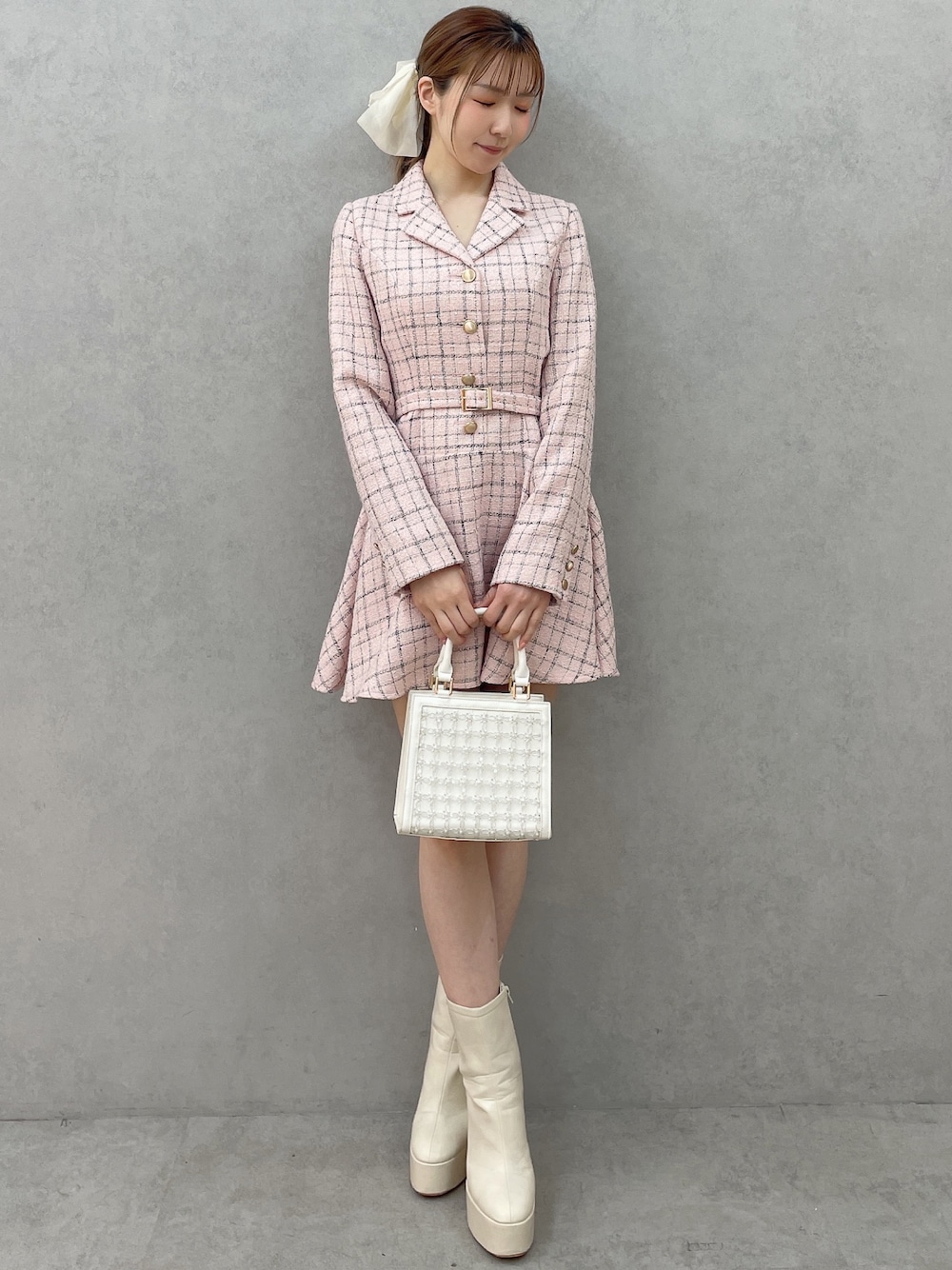 ピンク系のワンピース、ホワイト系のハンドバッグ、ホワイト系のブーツを着用したレディースの春コーディネートの1枚目の写真