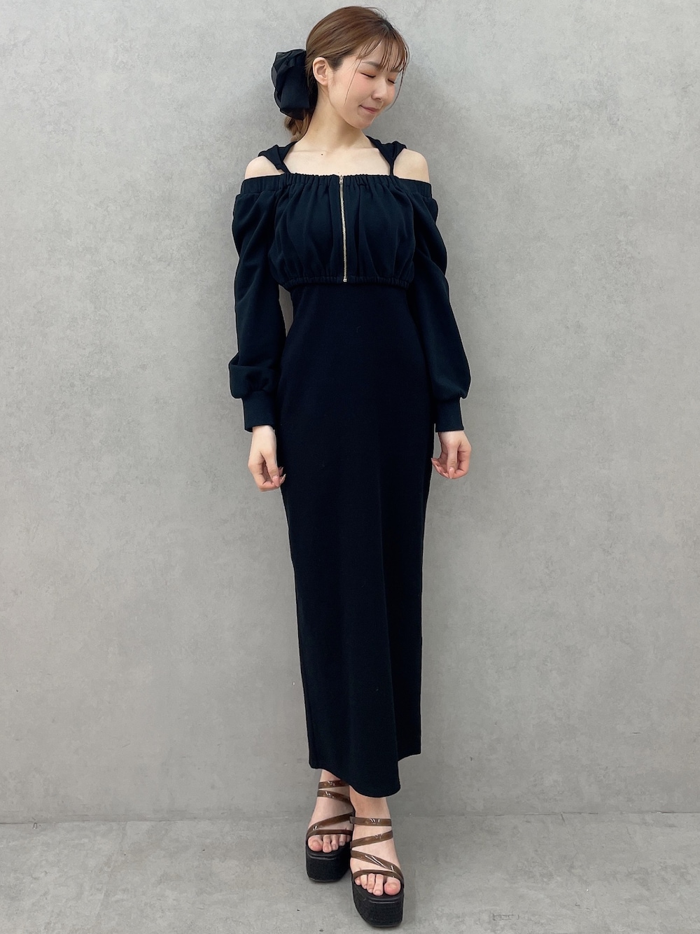 ブラック系のワンピース、ブラック系のサンダル、ブラック系のバレッタ/ヘアクリップを着用したレディースの春コーディネートの1枚目の写真