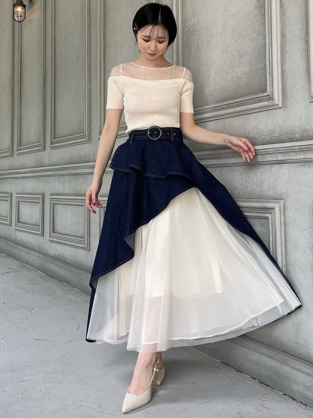 ブルー系のスカート、ホワイト系のニット/セーター、ベージュ系のサンダルを着用したレディースの夏コーディネートの1枚目の写真