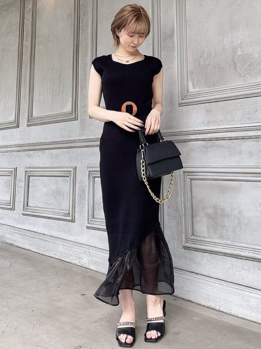 ブラック系のワンピース、ブラック系のサンダル、ブラック系のショルダーバッグを着用したレディースの春コーディネートの1枚目の写真