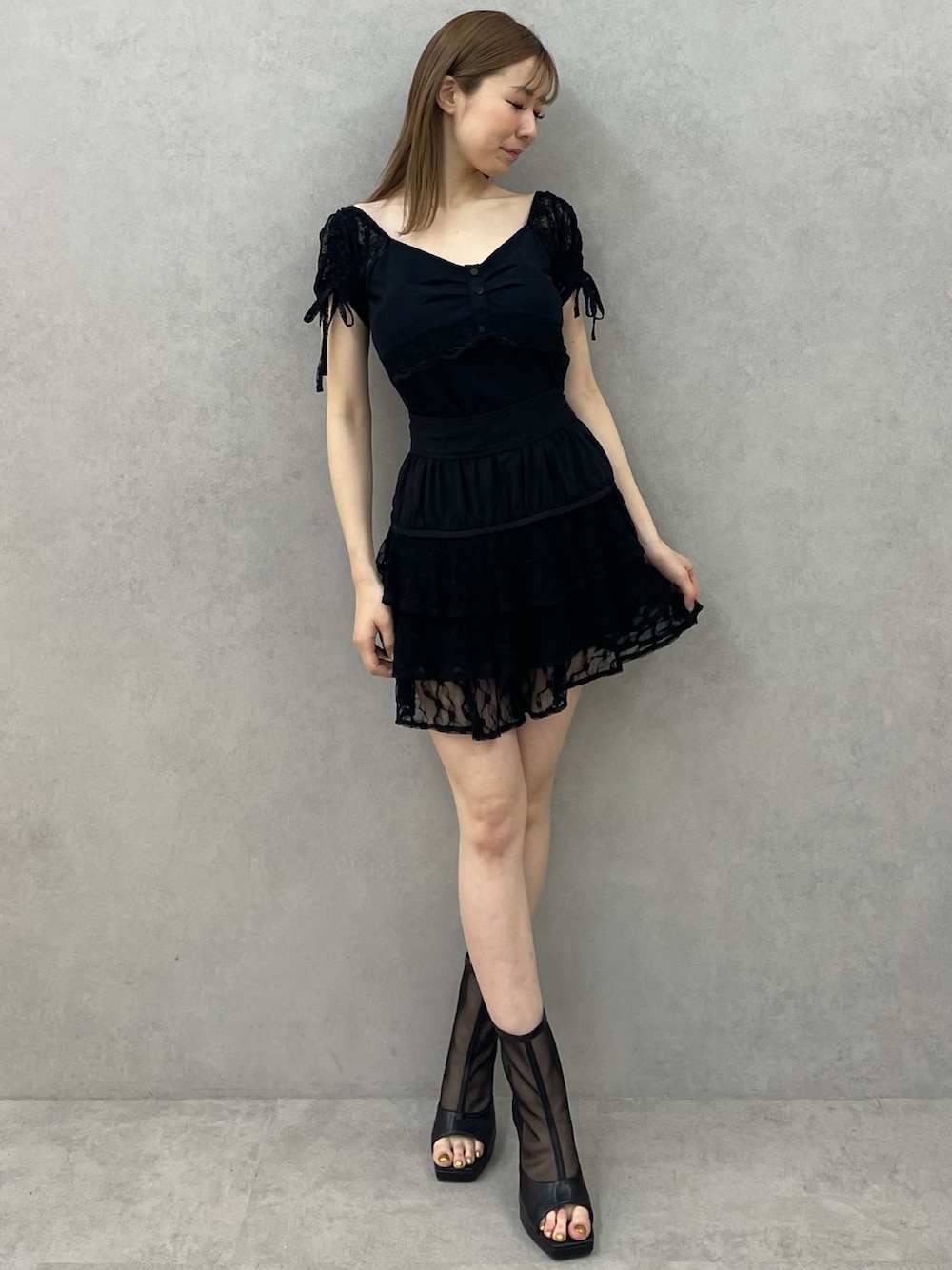 ブラック系のTシャツ/カットソー、ブラック系のスカート、ブラック系のブーツを着用したレディースの春コーディネートの1枚目の写真