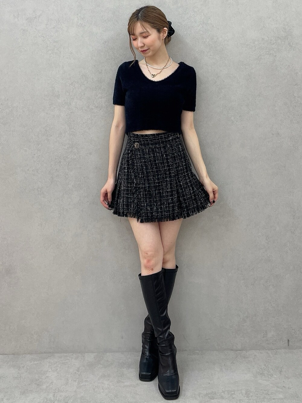ブラック系のニット/セーター、ブラック系のスカート、ブラック系のシュシュを着用したレディースの夏コーディネートの1枚目の写真