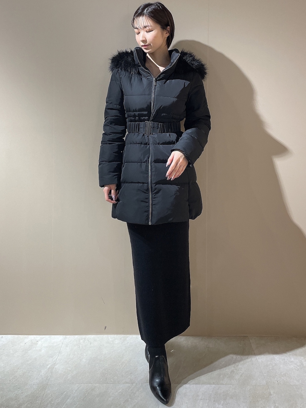 ブラック系のダウンジャケット/コート、ブラック系のワンピース、ブラック系のブーツを着用したレディースの秋コーディネートの1枚目の写真