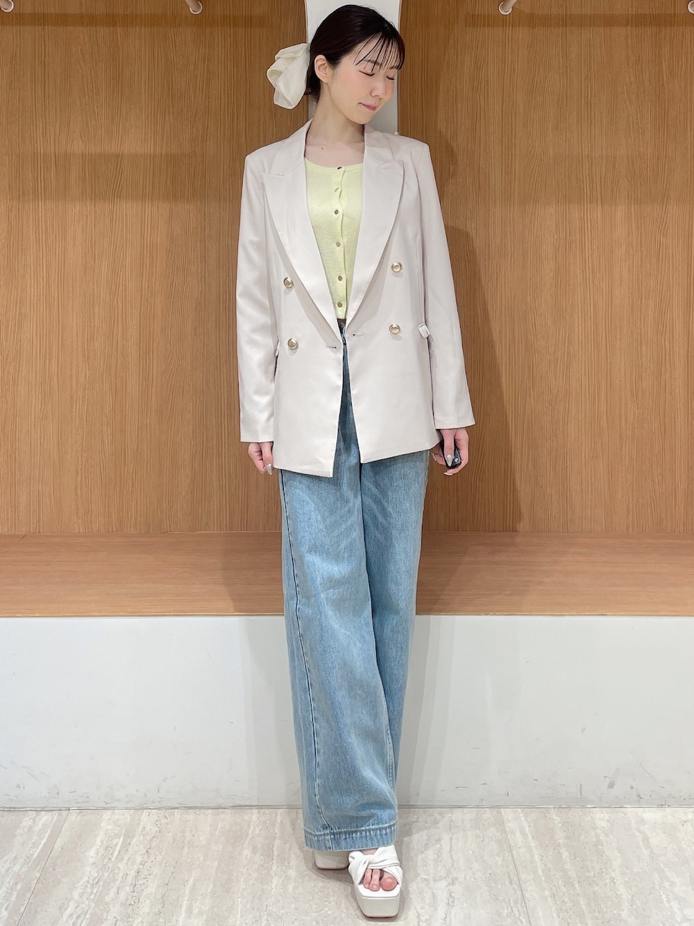 ホワイト系のテーラードジャケット、イエロー系のカーディガン/ボレロ、ブルー系のデニムパンツを着用したレディースの春コーディネートの1枚目の写真