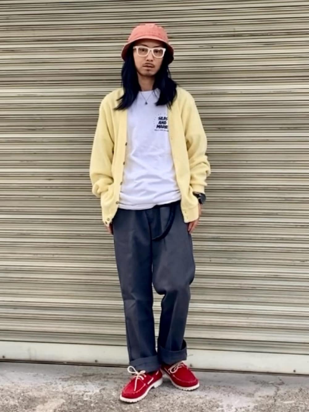 グレー系のチノパンツ、ホワイト系のTシャツ/カットソー、イエロー系のカーディガン/ボレロを着用したメンズの秋コーディネートの1枚目の写真