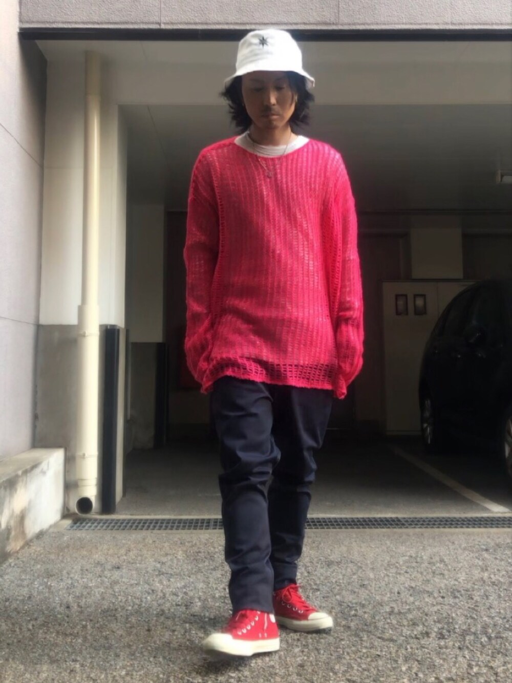 ブルー系のチノパンツ、レッド系のスニーカー、ホワイト系のハットを着用したメンズの春コーディネートの1枚目の写真