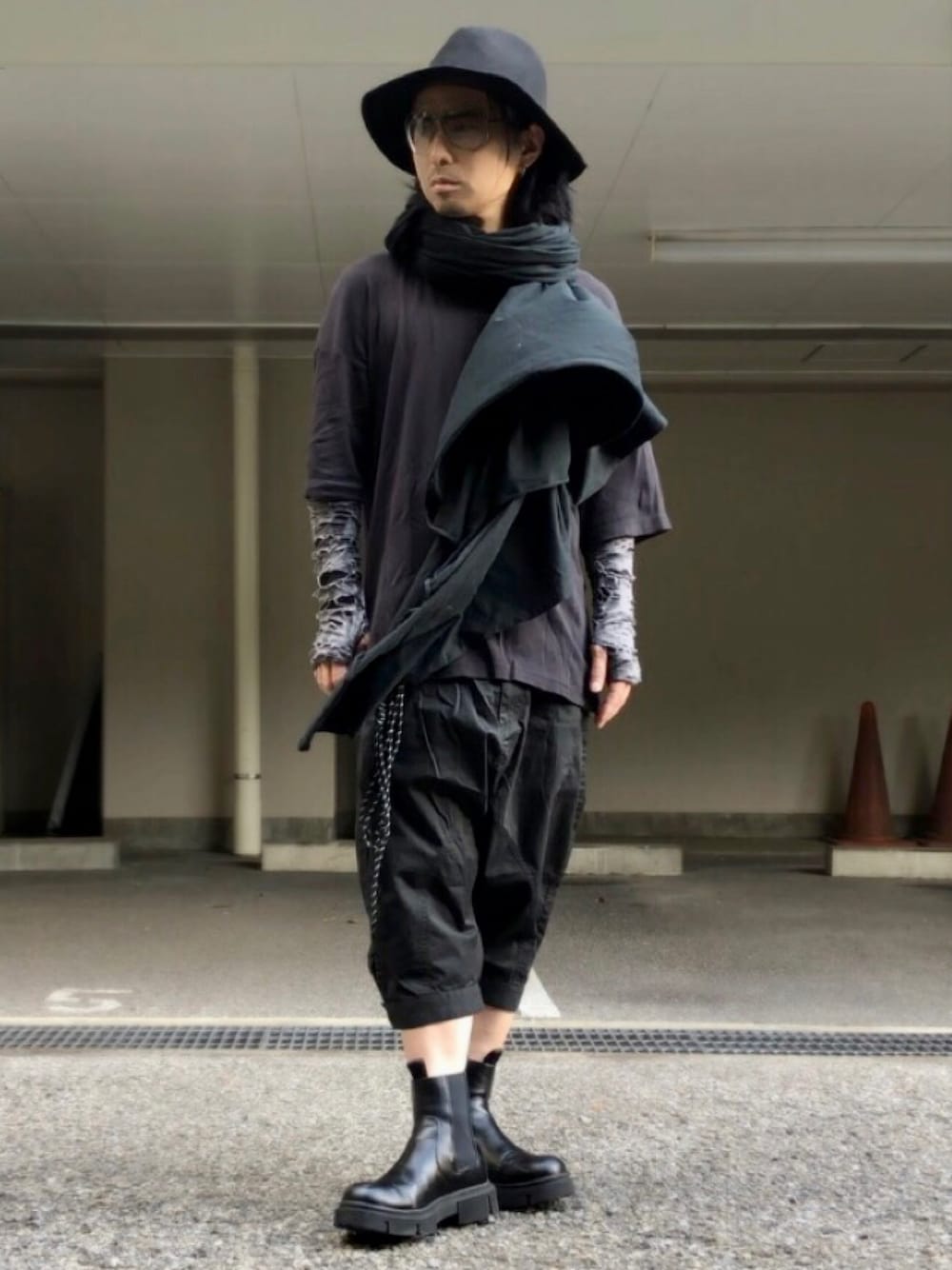 ブラック系のその他パンツ、ブラック系のサングラス、ブラック系のストール/ショールを着用したメンズの春コーディネートの1枚目の写真