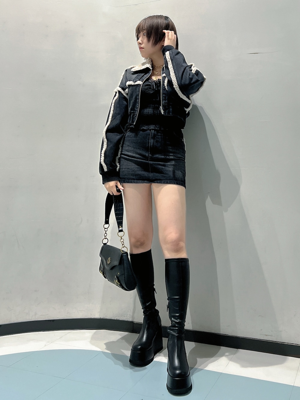 ブラック系のブルゾン、ブラック系のTシャツ/カットソー、ブラック系のデニムスカートを着用したレディースの秋コーディネートの1枚目の写真