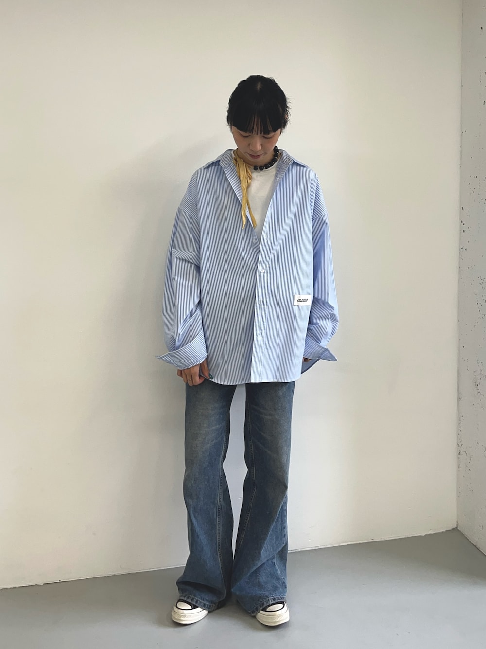 ブルー系のシャツ/ブラウス、ブラック系のスニーカー、ホワイト系のTシャツ/カットソーを着用したレディースの夏コーディネートの1枚目の写真