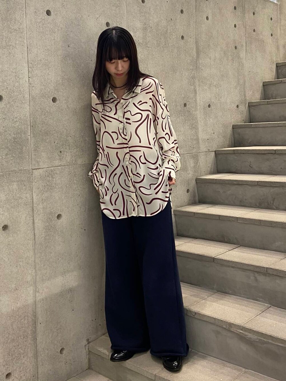 レッド系のシャツ/ブラウス、ブラック系のローファー、ブルー系のスウェットパンツを着用したレディースの冬コーディネートの1枚目の写真