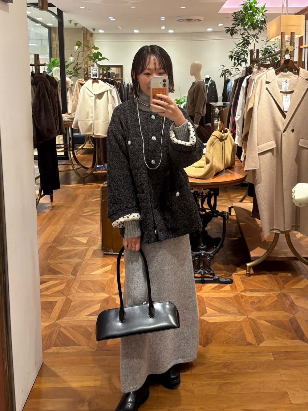 グレー系のノーカラージャケット、グレー系のワンピース、ブラック系のバッグを着用したレディースの秋コーディネートの1枚目の写真