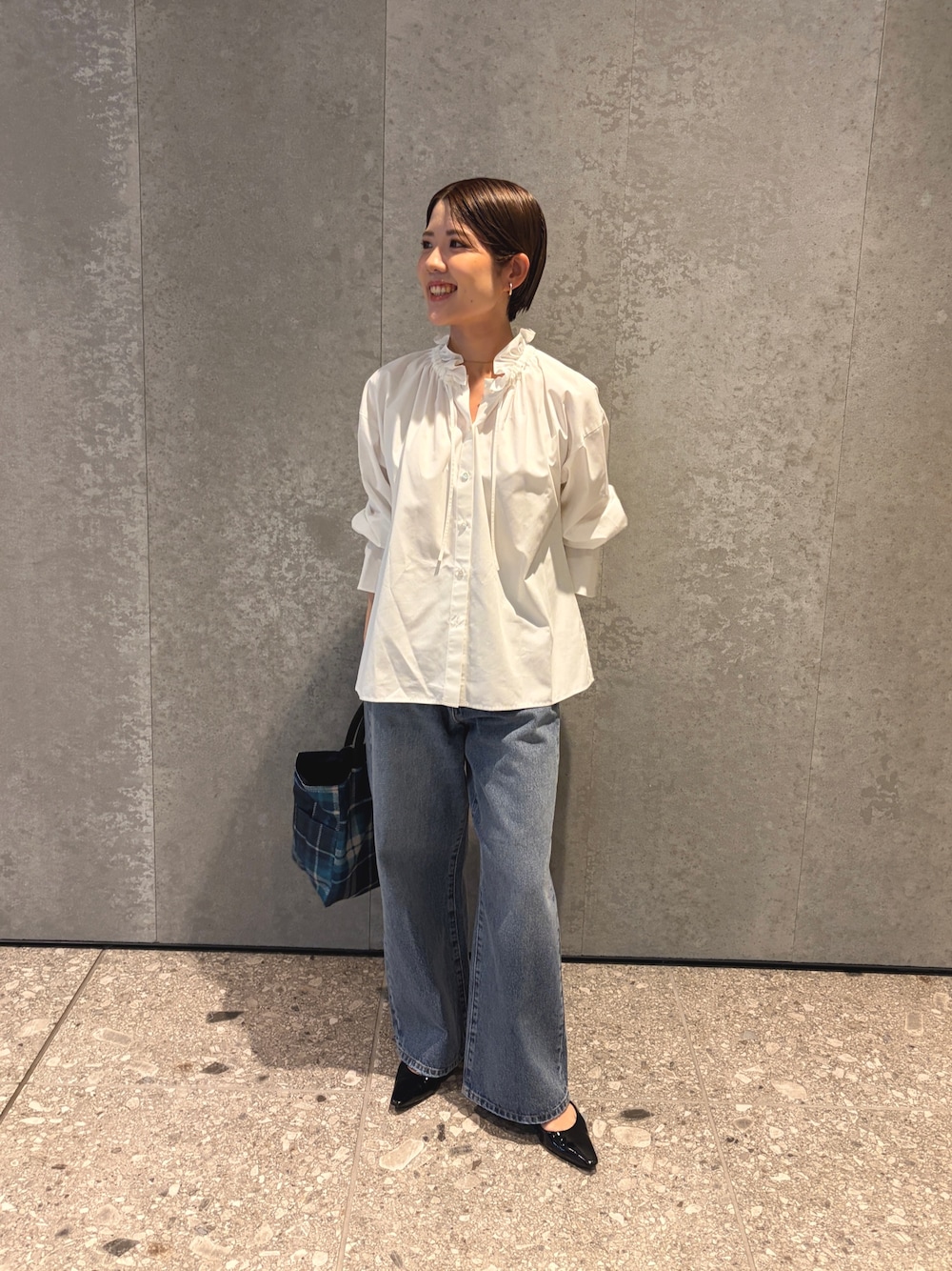 ブルー系のデニムパンツ、ブルー系のトートバッグ、ブラック系のパンプスを着用したレディースの夏コーディネートの1枚目の写真
