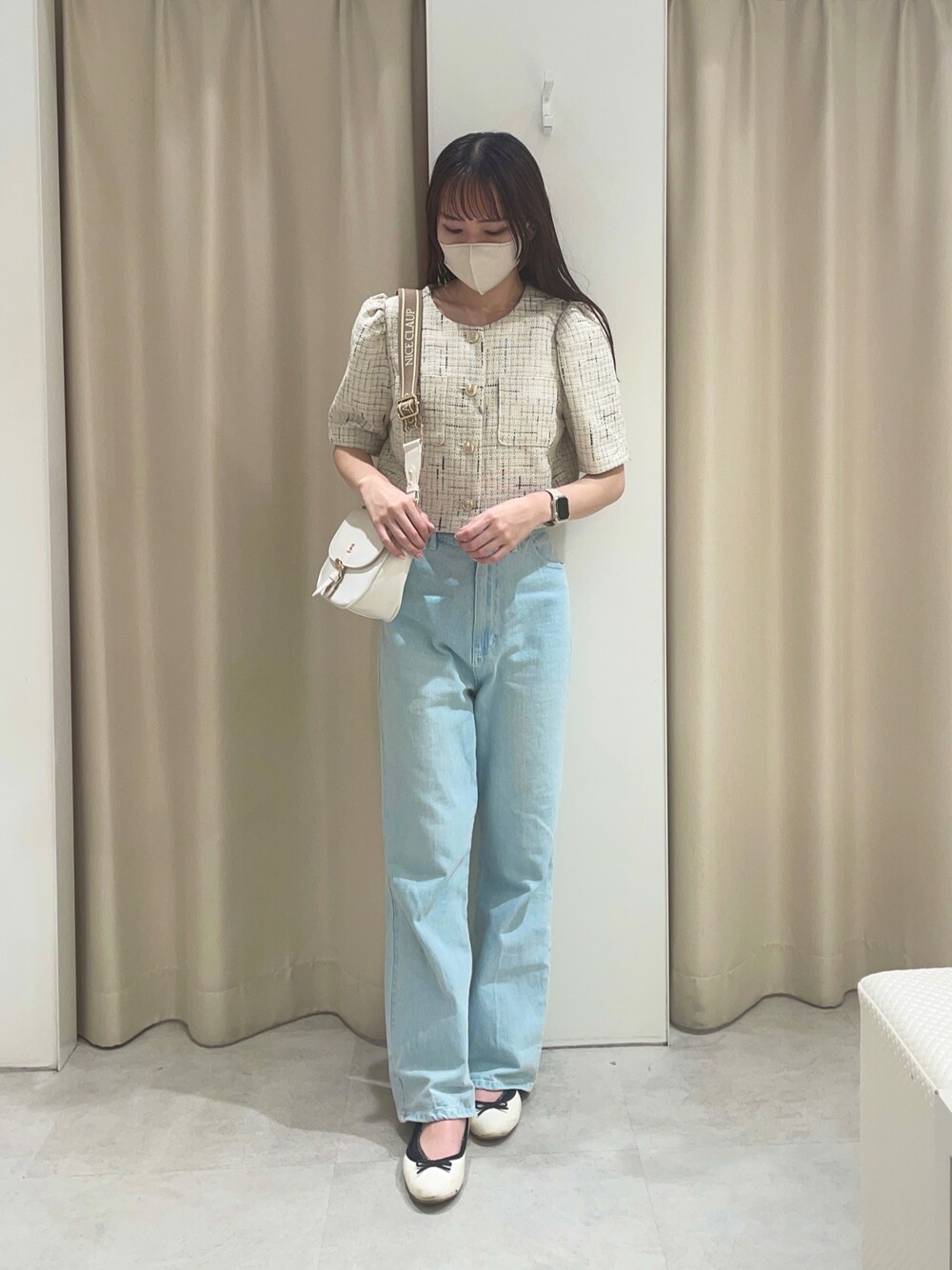 ホワイト系のノーカラージャケット、ブルー系のデニムパンツ、ホワイト系のショルダーバッグを着用したレディースの夏コーディネートの1枚目の写真