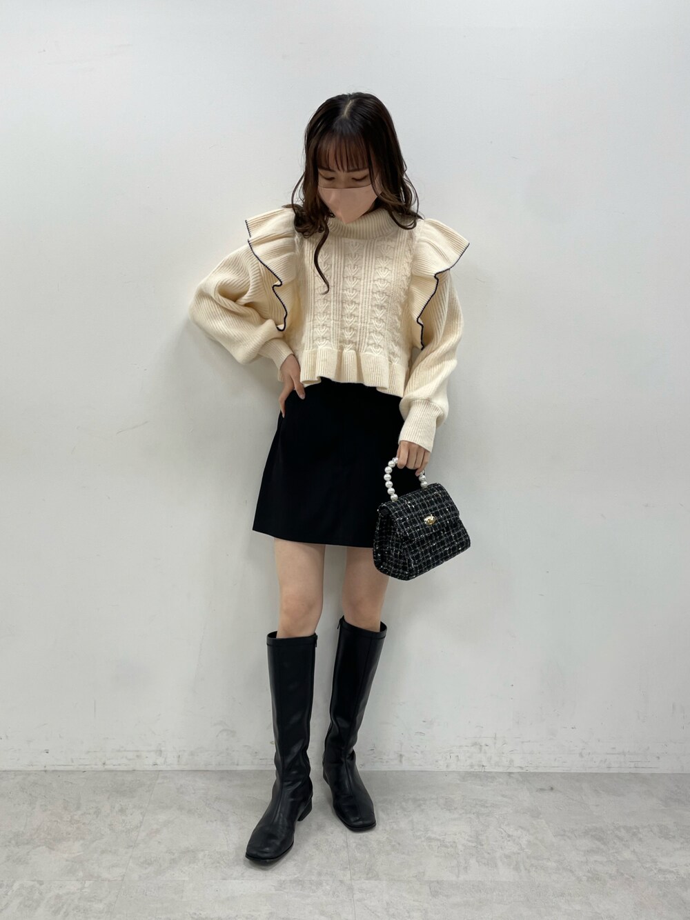 ホワイト系のニット/セーター、ブラック系のその他パンツ、ブラック系のショルダーバッグを着用したレディースの秋コーディネートの1枚目の写真