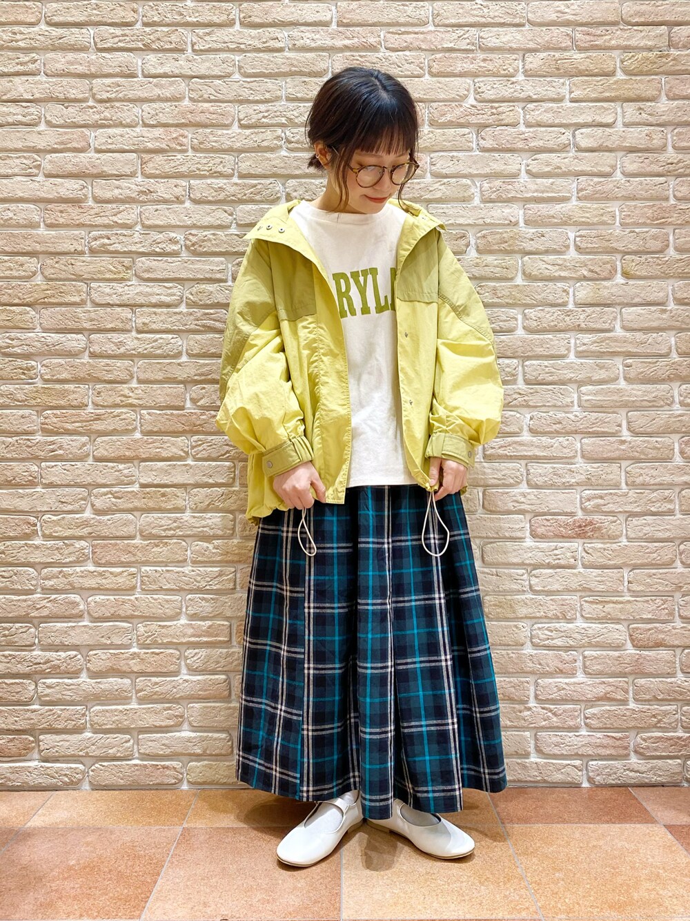 イエロー系のブルゾン、ホワイト系のTシャツ/カットソー、ブルー系のスカートを着用したレディースの春コーディネートの1枚目の写真