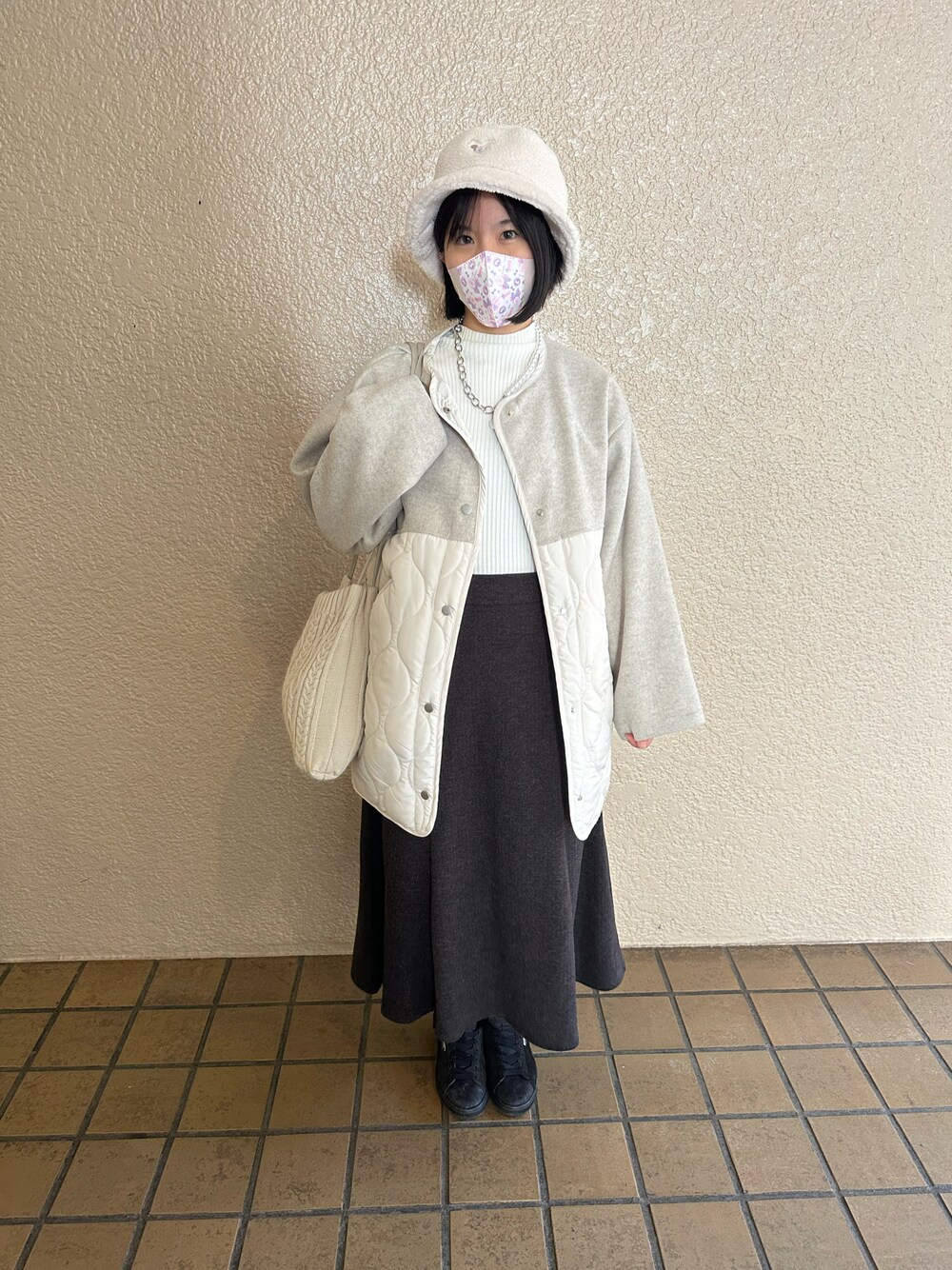 ホワイト系のニット/セーター、グレー系のスカート、ホワイト系のジャケット/アウターを着用したレディースの秋コーディネートの1枚目の写真