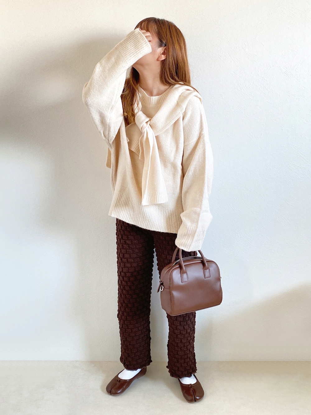 その他のニット/セーター、ブラウン系のその他パンツ、ブラウン系のボストンバッグを着用したレディースの秋コーディネートの1枚目の写真