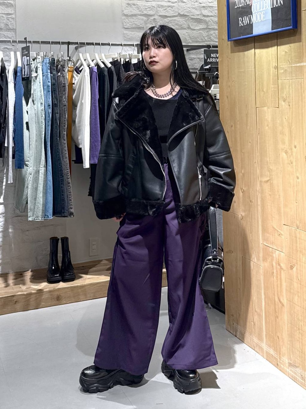 ブラック系のライダースジャケット、パープル系のその他パンツ、ブラック系のショルダーバッグを着用したレディースの秋コーディネートの1枚目の写真