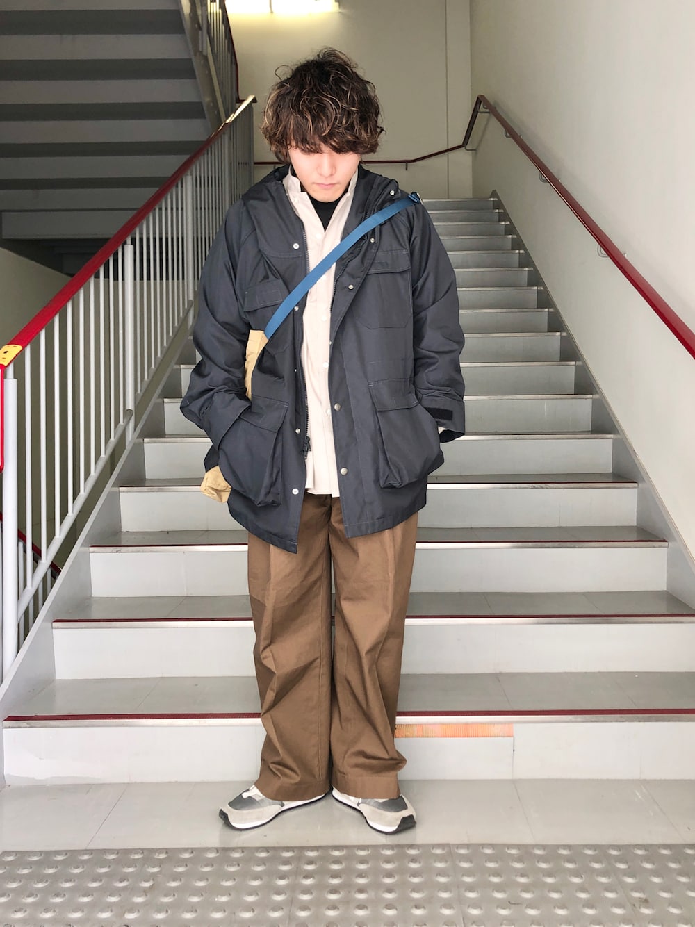 ブラウン系のその他パンツ、グレー系のスニーカー、ブラック系のマウンテンパーカーを着用したメンズの春コーディネートの1枚目の写真