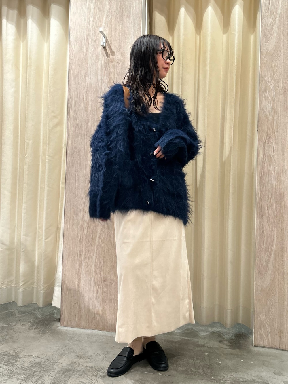 ブルー系のカーディガン/ボレロ、ベージュ系のスカートを着用したレディースの秋コーディネートの1枚目の写真