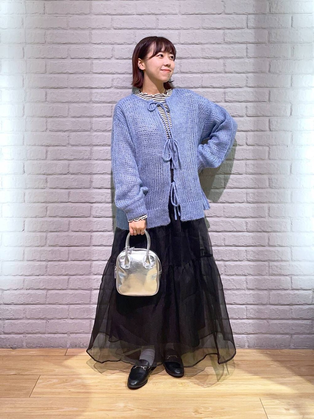 ブラック系のローファー、ブラック系のスカート、ブルー系のニット/セーターを着用したレディースの秋コーディネートの1枚目の写真