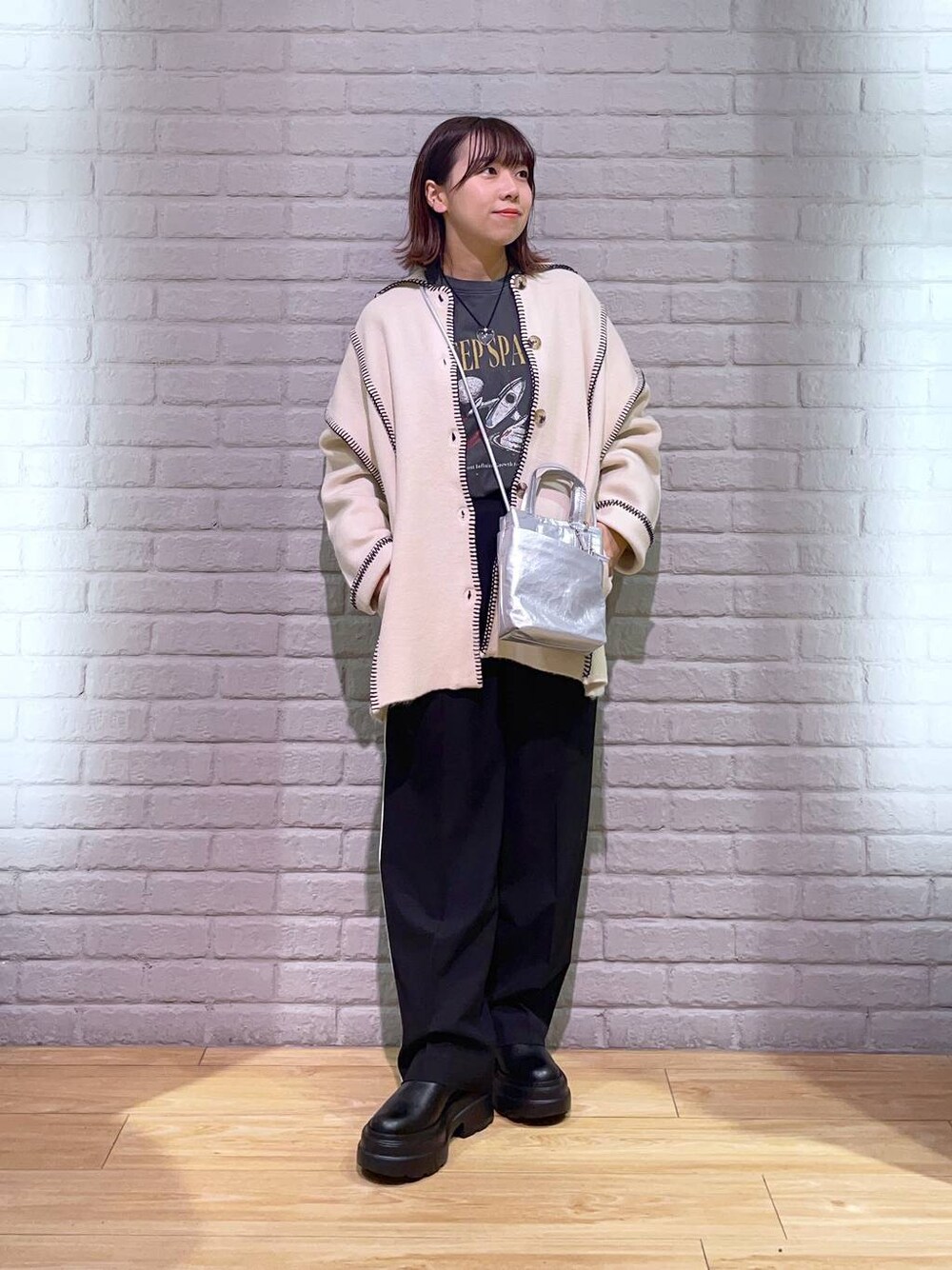 ブラック系のその他パンツ、ブラック系のブーツ、シルバー系のショルダーバッグを着用したレディースの秋コーディネートの1枚目の写真