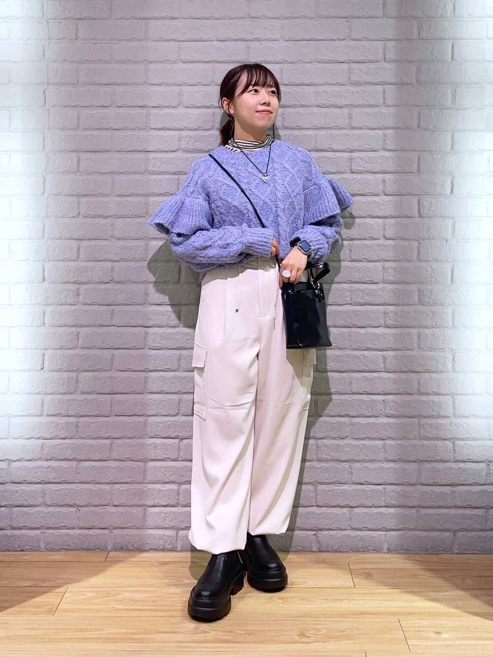 ホワイト系のTシャツ/カットソー、パープル系のニット/セーター、ブラック系のブーツを着用したレディースの秋コーディネートの1枚目の写真