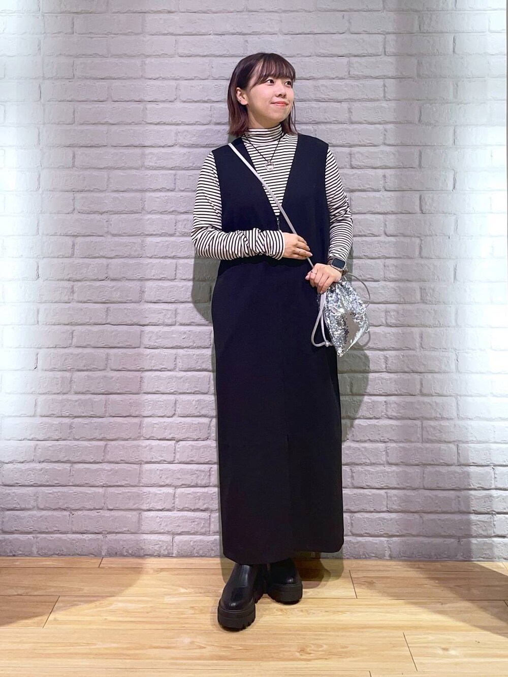 ホワイト系のTシャツ/カットソー、ブラック系のワンピース、ブラック系のブーツを着用したレディースの秋コーディネートの1枚目の写真