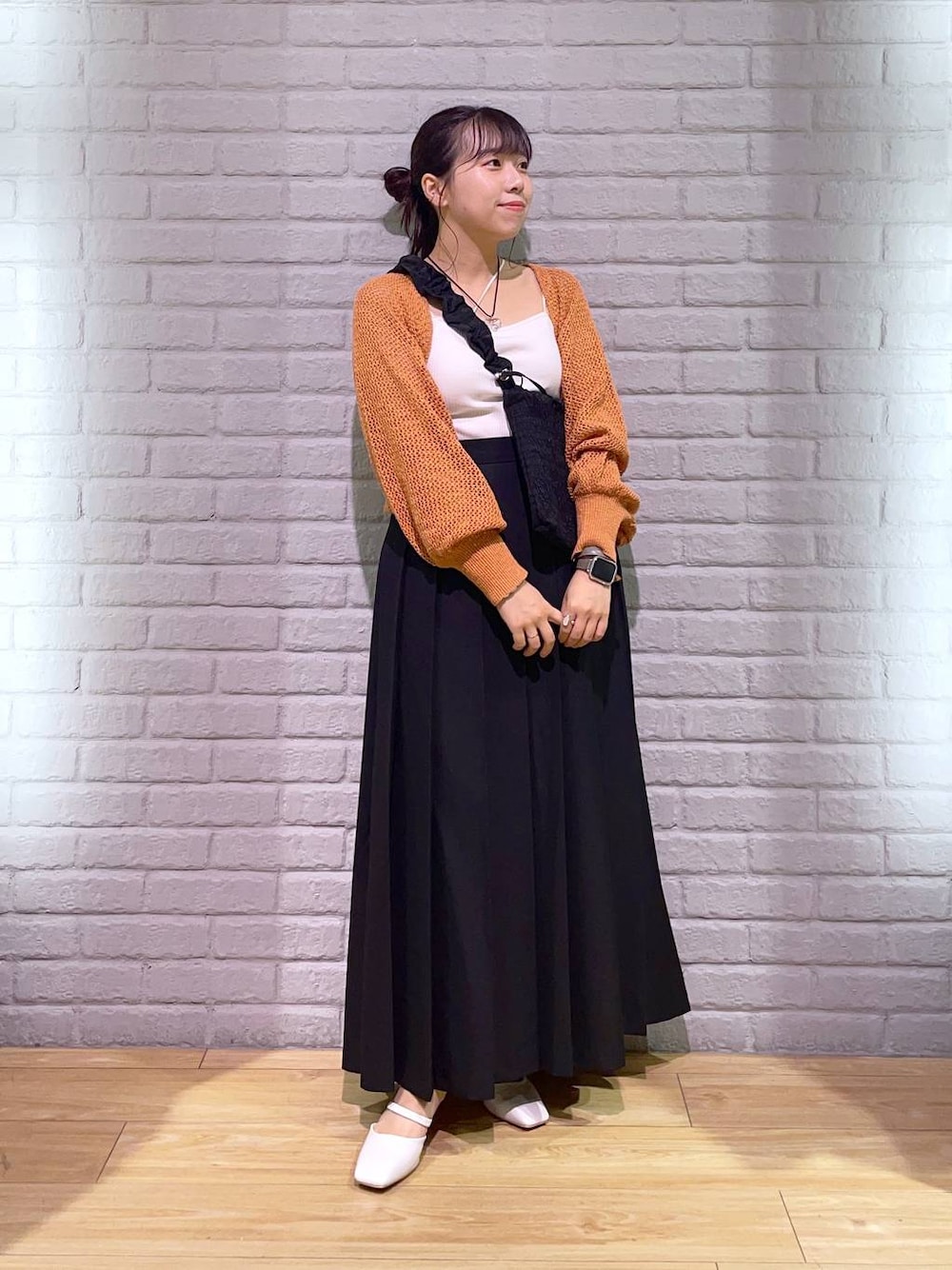 ホワイト系のタンクトップ、ホワイト系のパンプス、ベージュ系のカーディガン/ボレロを着用したレディースの夏コーディネートの1枚目の写真