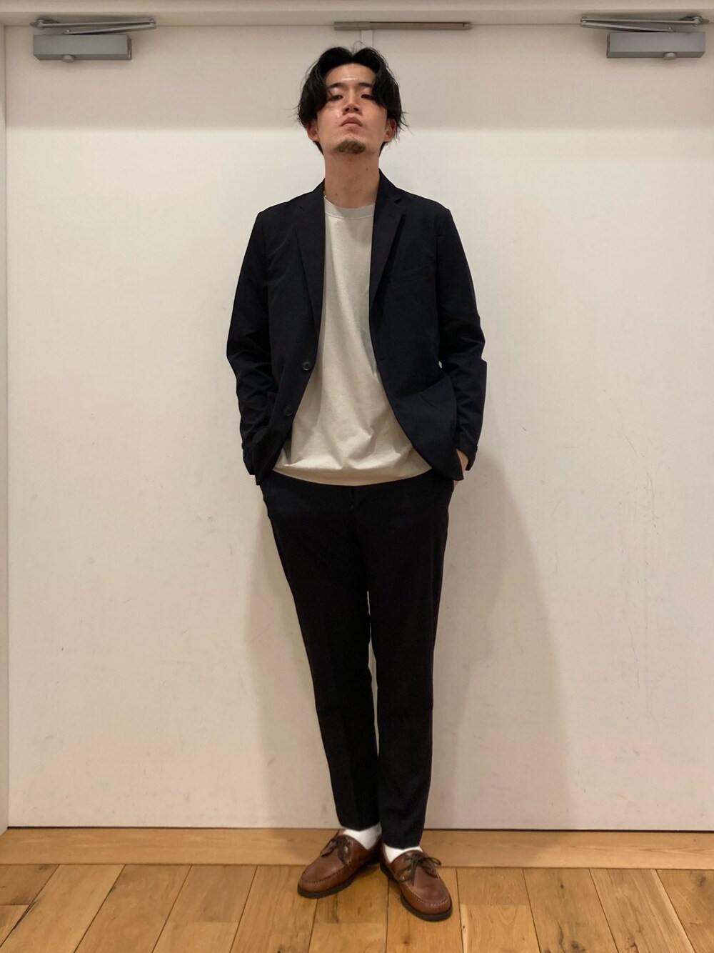ブルー系のスーツパンツ、ブラウン系のモカシン/デッキシューズ、ブルー系のスーツジャケットを着用したメンズの春コーディネートの1枚目の写真