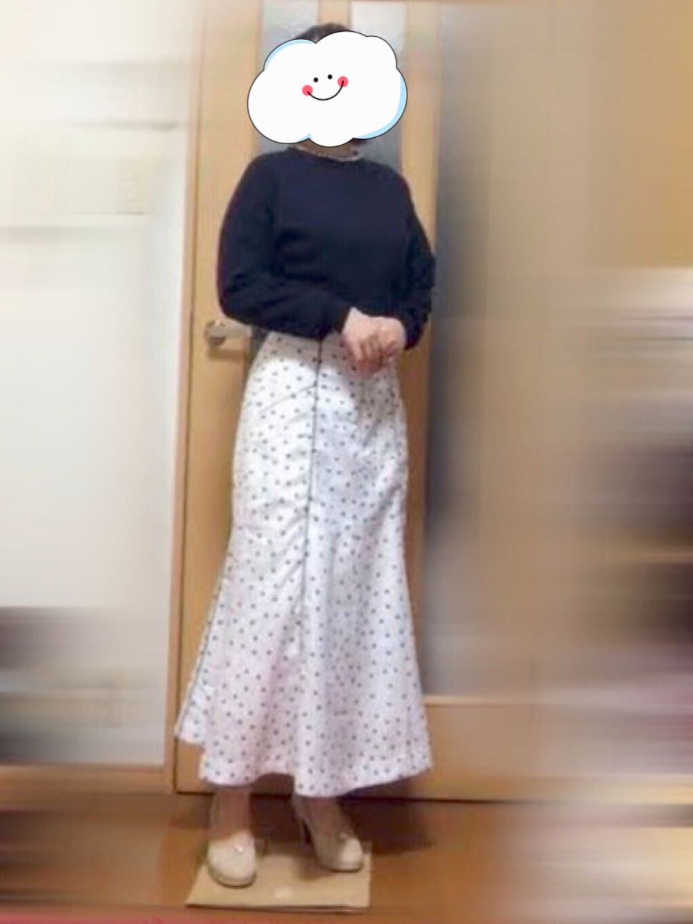 ベージュ系のパンプス、ブルー系のカーディガン/ボレロ、ホワイト系のスカートを着用したレディースの冬コーディネートの1枚目の写真