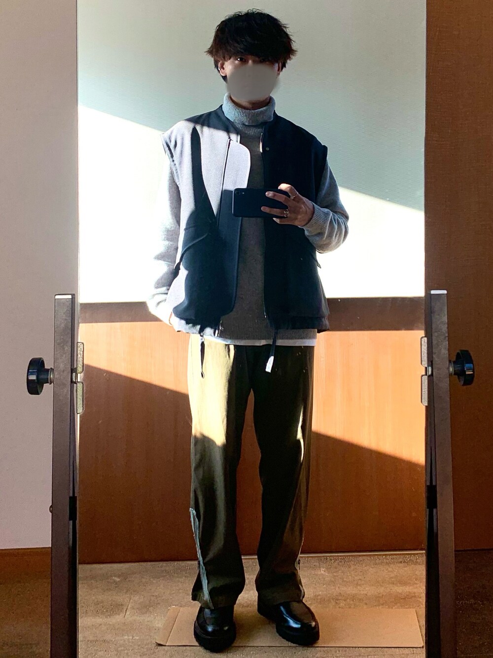 グレー系のブルゾン、グレー系のニット/セーター、グリーン系のカーゴパンツを着用したメンズの冬コーディネートの1枚目の写真