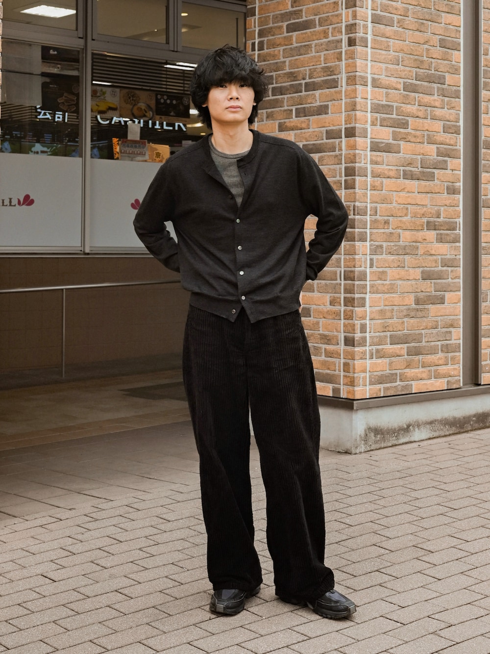 ブラック系のスニーカー、イエロー系のTシャツ/カットソー、ブラック系のカーディガン/ボレロを着用したメンズの春コーディネートの1枚目の写真