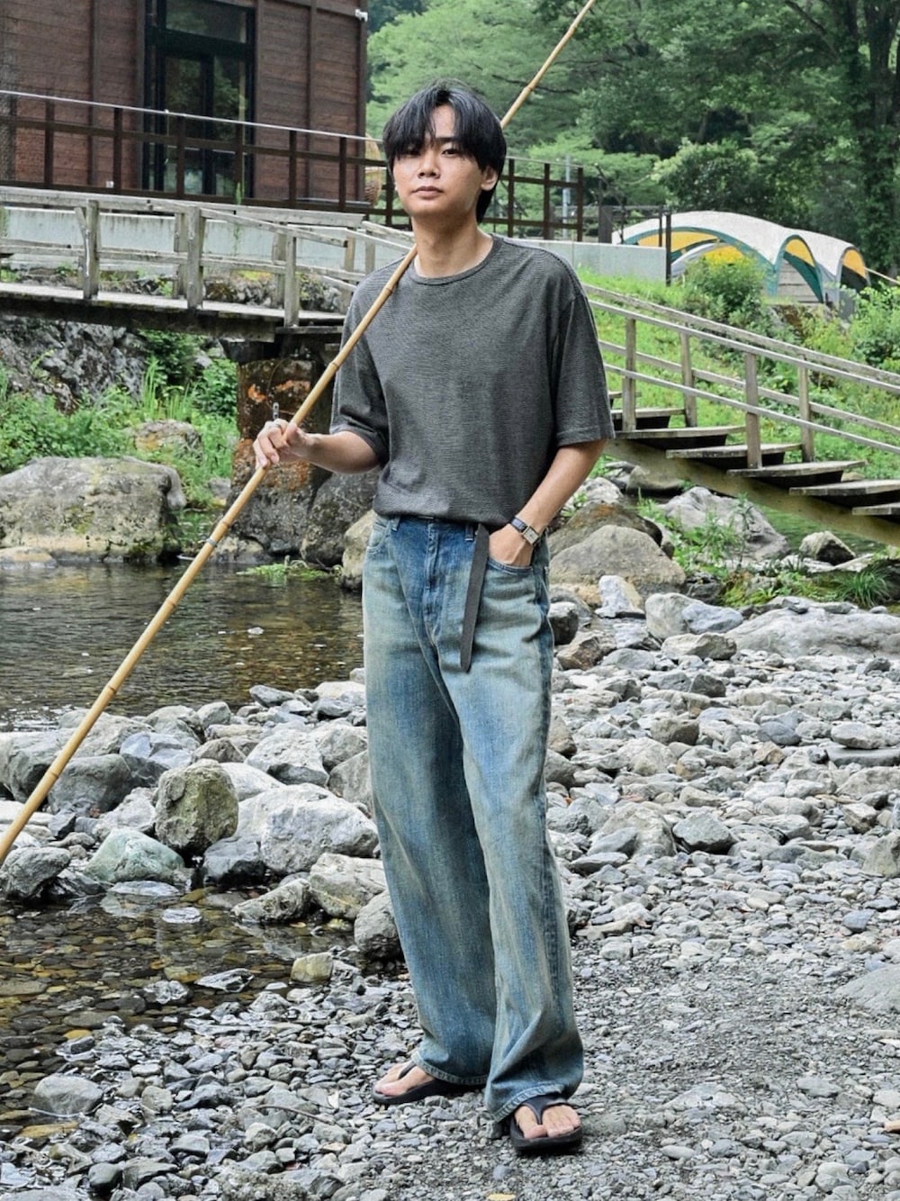 ブラック系のサンダル、イエロー系のTシャツ/カットソー、ブルー系のデニムパンツを着用したメンズの夏コーディネートの1枚目の写真