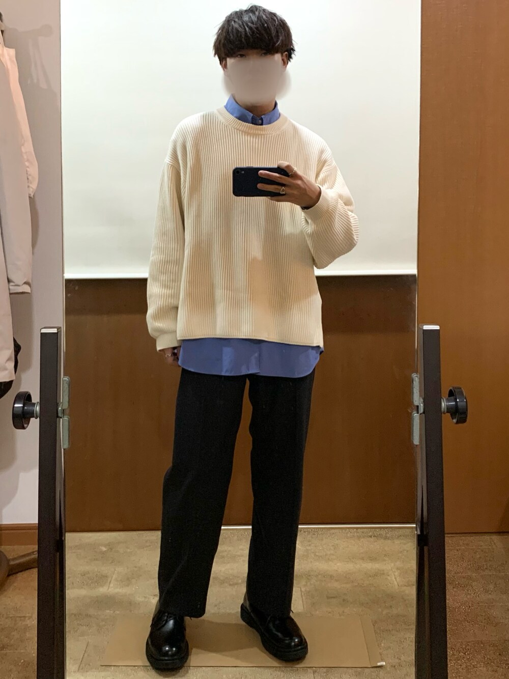 ブラック系のスラックス、ブルー系のシャツ/ブラウス、ホワイト系のニット/セーターを着用したメンズの冬コーディネートの1枚目の写真