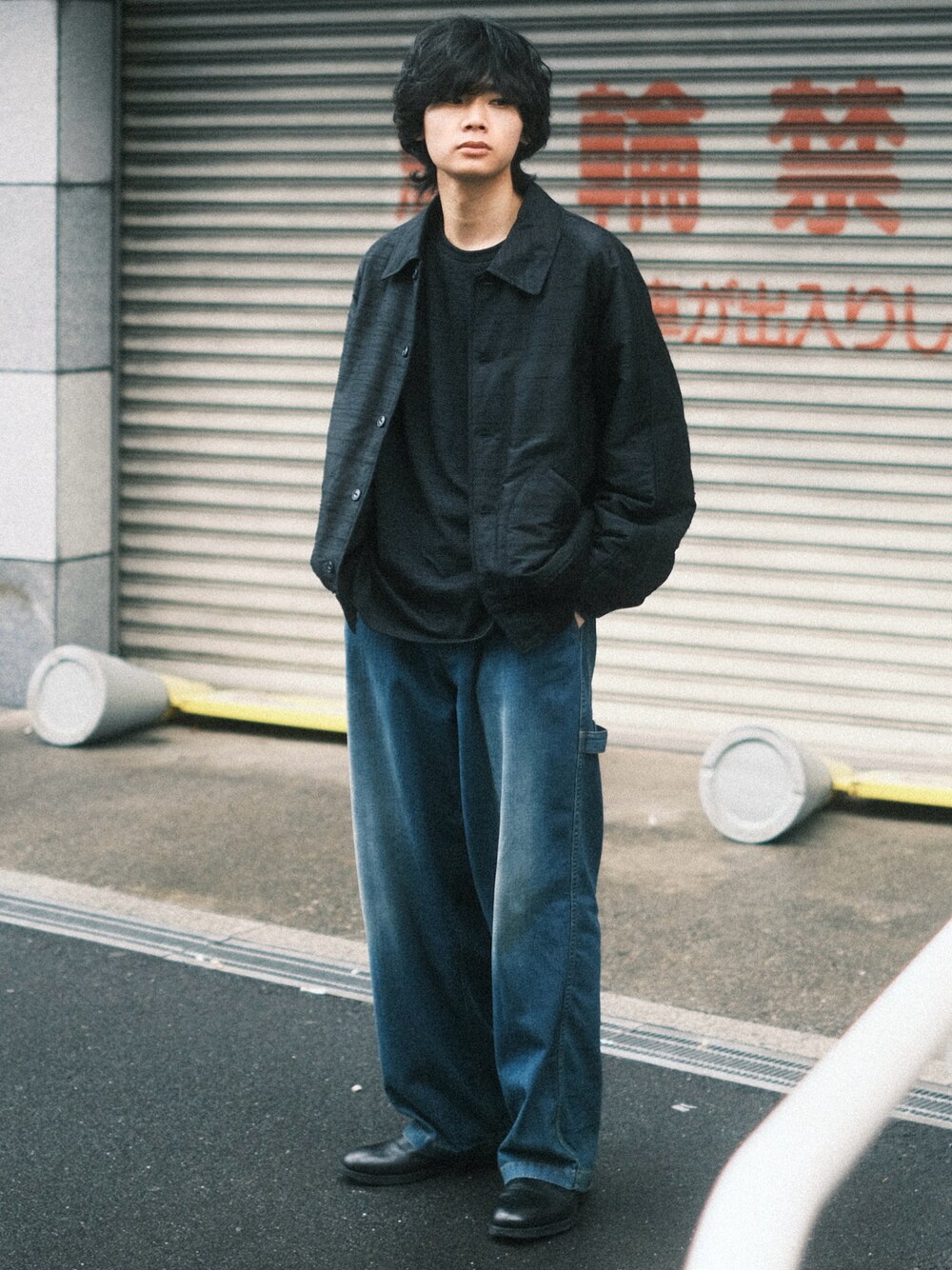 ブルー系のデニムパンツ、ブラック系のTシャツ/カットソー、ブラック系のブルゾンを着用したメンズの春コーディネートの1枚目の写真