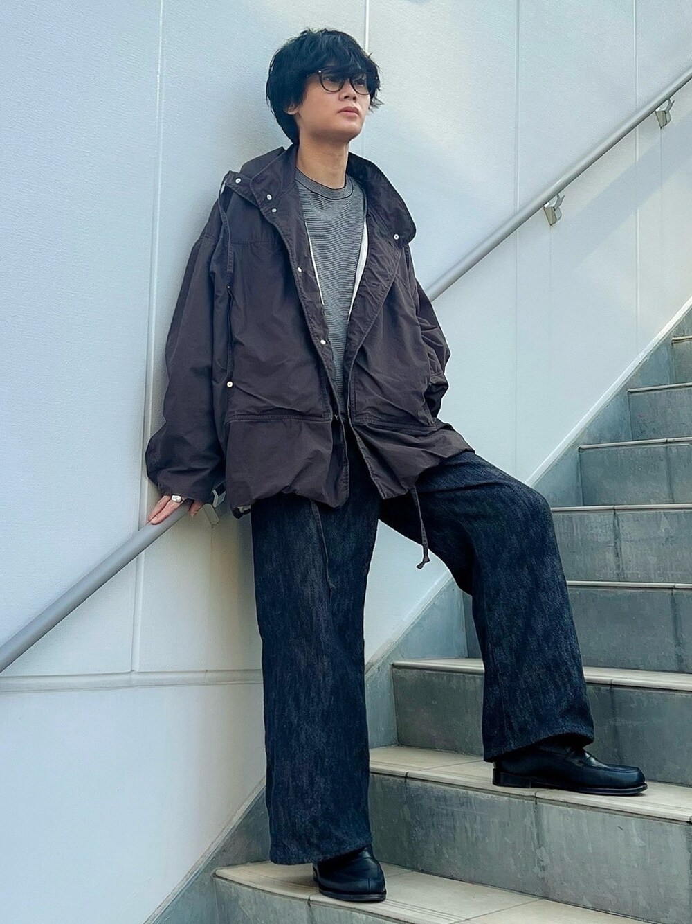 ブラウン系のブルゾン、ブラック系のデニムパンツ、グレー系のニット/セーターを着用したメンズの冬コーディネートの1枚目の写真