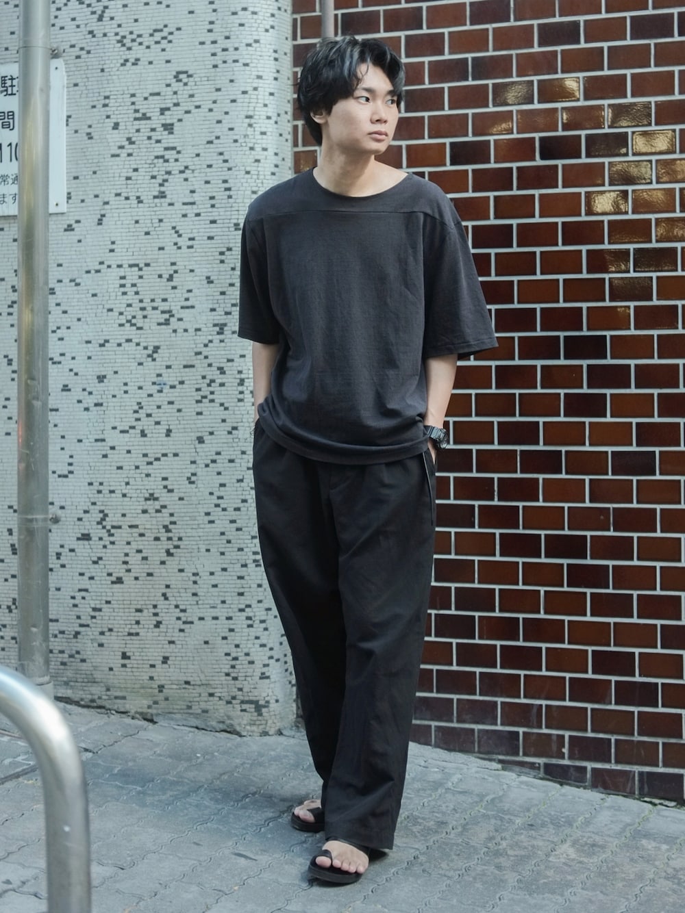 ブラック系のTシャツ/カットソー、ブラック系のパンツ、ブラック系のサンダルを着用したメンズの夏コーディネートの1枚目の写真
