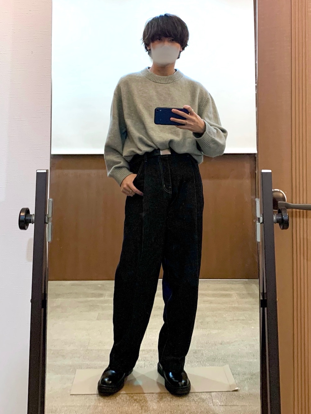 ブルー系のデニムパンツ、グレー系のニット/セーター、ブラック系のドレスシューズを着用したメンズの冬コーディネートの1枚目の写真