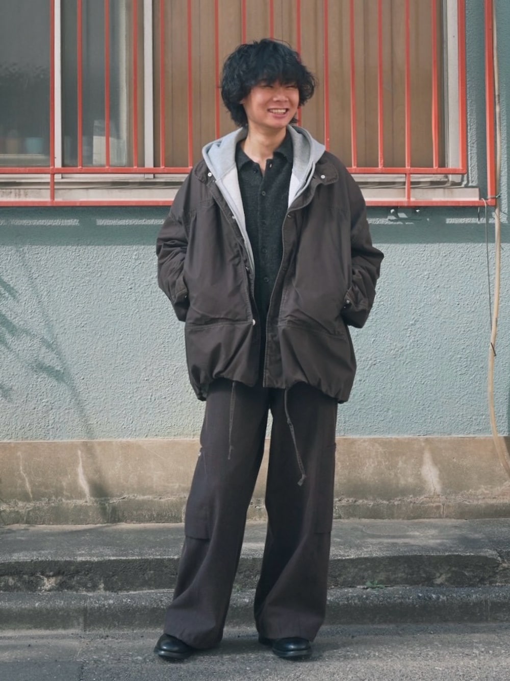 ブラック系のブーツ、グレー系のパーカー、ブラック系のカーディガン/ボレロを着用したメンズの春コーディネートの1枚目の写真