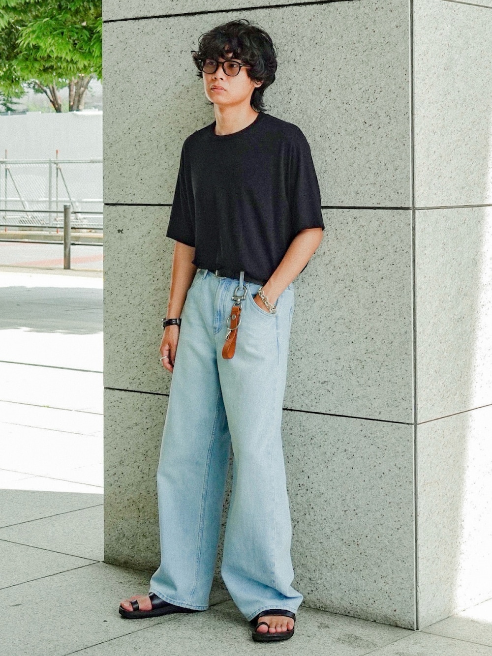 グレー系のTシャツ/カットソー、ブラック系のサンダル、ブルー系のデニムパンツを着用したメンズの夏コーディネートの1枚目の写真