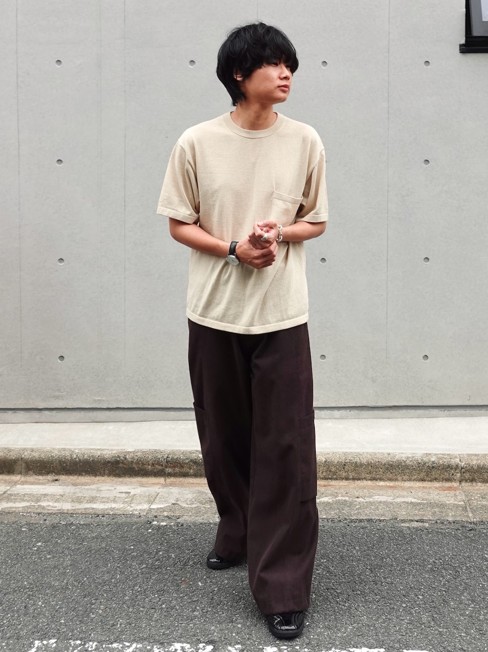 ブラウン系のカーゴパンツ、ブラック系のスニーカー、シルバー系のアナログ腕時計を着用したメンズの春コーディネートの1枚目の写真
