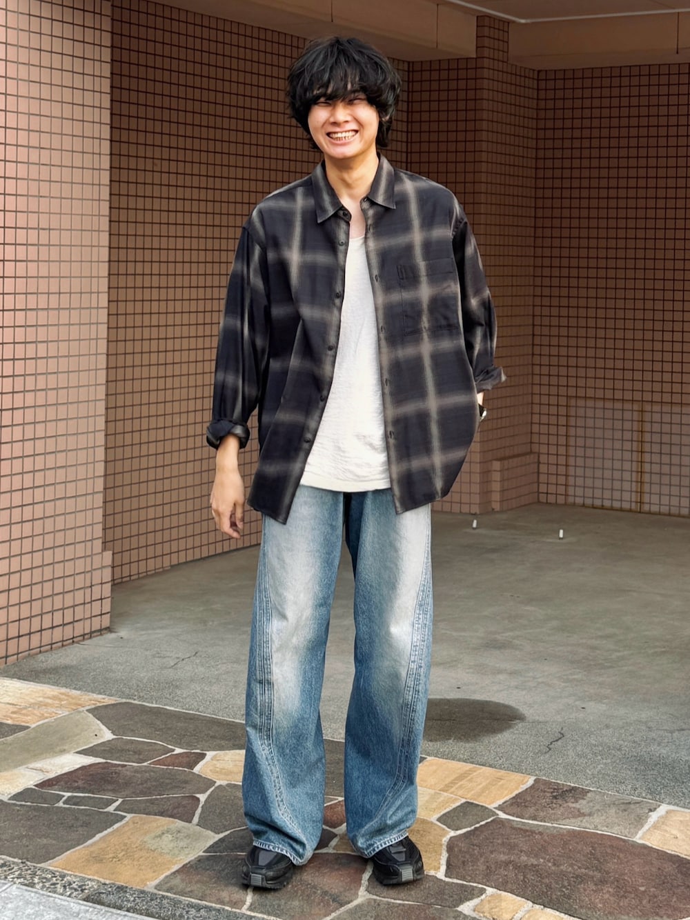 ブルー系のデニムパンツ、ブラック系のスニーカー、ホワイト系のタンクトップを着用したメンズの春コーディネートの1枚目の写真