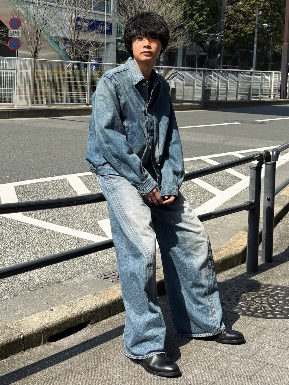 ブルー系のデニムジャケット、ブルー系のデニムパンツ、ブラック系のブーツを着用したメンズの春コーディネートの1枚目の写真